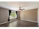 Bright bedroom featuring wood-look floors, a ceiling fan, and a large window at 6743 S Jentilly Ln, Tempe, AZ 85283