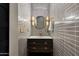 Bathroom vanity with a dark wood cabinet, modern tile backsplash, and gold fixtures at 7710 N Via De Fonda St, Scottsdale, AZ 85258