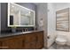 Bathroom featuring modern fixtures, vanity with a wood finish, and a stylish, well-lit mirror at 7710 N Via De Fonda St, Scottsdale, AZ 85258