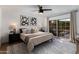 A modern bedroom featuring a sliding glass door and a neutral color palette at 7710 N Via De Fonda St, Scottsdale, AZ 85258