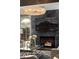 Close-up of the marble fireplace with a mounted flatscreen TV and modern glass table at 7710 N Via De Fonda St, Scottsdale, AZ 85258