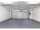 Clean and spacious garage with a freshly epoxied floor, new garage door, and overhead lighting at 7710 N Via De Fonda St, Scottsdale, AZ 85258