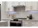 Close-up on a range with stainless steel hood and white subway tile backsplash at 7710 N Via De Fonda St, Scottsdale, AZ 85258