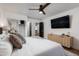 Well-lit main bedroom featuring a ceiling fan, a TV, stylish décor, and a cozy queen-sized bed at 7710 N Via De Fonda St, Scottsdale, AZ 85258