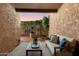 Charming covered patio with textured walls, ample seating, and a view of the professionally landscaped yard at 7710 N Via De Fonda St, Scottsdale, AZ 85258