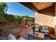 Charming covered patio with brick flooring, comfortable seating, and a well-maintained garden with mature trees and greenery at 7710 N Via De Fonda St, Scottsdale, AZ 85258