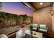 Inviting covered patio with brick flooring, cozy seating, and lush green landscaping perfect for outdoor relaxation and entertainment at 7710 N Via De Fonda St, Scottsdale, AZ 85258