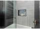 Close-up of the shower, showcasing a built-in niche, tiled walls, and bronze fixtures at 7710 N Via De Fonda St, Scottsdale, AZ 85258