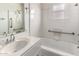 Clean bathroom featuring a white vanity, shower, and tiled tub with safety bars and window at 813 N Gilbert Ave, Casa Grande, AZ 85122
