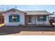 Quaint single-level house featuring vibrant blue shutters and a covered porch at 813 N Gilbert Ave, Casa Grande, AZ 85122