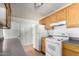 Classic kitchen with wooden cabinets, white appliances, and neutral countertops at 813 N Gilbert Ave, Casa Grande, AZ 85122