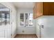 Bright laundry room with tile flooring, utility sink, wood cabinet, and large window at 813 N Gilbert Ave, Casa Grande, AZ 85122