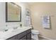 Bathroom with a single sink vanity, dark brown cabinets, a decorative mirror, and neutral walls at 8606 W Caribbean Ln, Peoria, AZ 85381