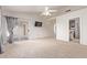 Carpeted bedroom featuring a ceiling fan, sliding doors to a screened in patio, and an ensuite bathroom at 8606 W Caribbean Ln, Peoria, AZ 85381