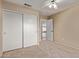Neutral carpeted bedroom with a ceiling fan, a double door closet and an open doorway at 8606 W Caribbean Ln, Peoria, AZ 85381