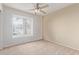Carpeted bedroom featuring neutral walls, a ceiling fan, and a window with blinds for natural light at 8606 W Caribbean Ln, Peoria, AZ 85381