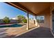 Covered patio provides shade and overlooks the pool and landscaped yard, perfect for outdoor living at 8606 W Caribbean Ln, Peoria, AZ 85381