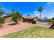 Spacious backyard with a pool, covered patio, mature trees, and gravel landscaping at 8913 W Country Club Trl, Peoria, AZ 85383