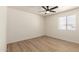 A sunlit bedroom featuring wood-look floors and a ceiling fan at 8913 W Country Club Trl, Peoria, AZ 85383