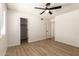 Bright bedroom featuring a ceiling fan, wood-look floors, and a closet at 8913 W Country Club Trl, Peoria, AZ 85383