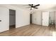 Bedroom featuring wood floors, neutral paint, a ceiling fan, and large closet at 8913 W Country Club Trl, Peoria, AZ 85383