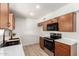 Modern kitchen with stainless steel appliances, wood cabinets, and light countertops at 8913 W Country Club Trl, Peoria, AZ 85383