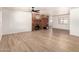 Spacious living room with wood-look flooring, brick fireplace with mantel, and neutral paint at 8913 W Country Club Trl, Peoria, AZ 85383