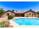 Beautiful backyard pool with a brick home and patio cover in the background at 8913 W Country Club Trl, Peoria, AZ 85383