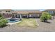 Expansive backyard featuring a pool, spa, lush landscaping, and an outdoor grilling area at 9576 W Blue Sky Dr, Peoria, AZ 85383