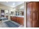 Primary bathroom with wood cabinets, dual sinks, decorative accents, and large mirror at 9576 W Blue Sky Dr, Peoria, AZ 85383