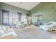 Large living room featuring a sofa, carpet flooring, and windows with shutters at 9576 W Blue Sky Dr, Peoria, AZ 85383