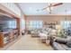 Comfortable living room with neutral decor, large sectional, and bright, shuttered windows at 9576 W Blue Sky Dr, Peoria, AZ 85383