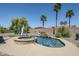 Backyard pool features a built-in spa, rock waterfall, and lush landscaping at 9576 W Blue Sky Dr, Peoria, AZ 85383