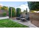 Secluded backyard with lounge chairs, manicured lawn, mature trees, and a serene setting for relaxation at 9721 E Juanita Ave, Mesa, AZ 85209