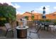 Outdoor kitchen with built-in grill, seating area with fire pit, and patio umbrella for outdoor enjoyment at 9721 E Juanita Ave, Mesa, AZ 85209