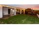 Spacious backyard featuring manicured lawn, covered patio, and outdoor lighting perfect for entertaining at 9721 E Juanita Ave, Mesa, AZ 85209