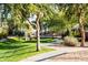 Scenic walking path through a beautifully landscaped community park with mature trees and green grass at 9721 E Juanita Ave, Mesa, AZ 85209