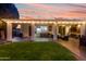 Inviting covered patio with ample seating, a TV, and outdoor bar area overlooking the lush backyard at 9721 E Juanita Ave, Mesa, AZ 85209