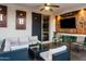 Comfortable covered patio features a ceiling fan, mounted TV, and cozy seating area, perfect for relaxation at 9721 E Juanita Ave, Mesa, AZ 85209