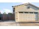 A two car garage with a decorative door and stone accents, and a gate to the backyard at 9721 E Juanita Ave, Mesa, AZ 85209