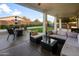 Covered patio featuring comfortable seating, an outdoor kitchen, and lush backyard views, perfect for relaxing at 9721 E Juanita Ave, Mesa, AZ 85209