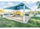 Community playground with a covered play structure and slides, surrounded by a grassy area, perfect for outdoor fun at 9721 E Juanita Ave, Mesa, AZ 85209
