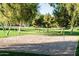 Sandy volleyball court surrounded by lush greenery, offering a fun recreational amenity for the community at 9721 E Juanita Ave, Mesa, AZ 85209