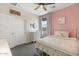 Light-filled bedroom with pink accent wall, plush bedding, and a window with a view at 9856 E Palladium Dr, Mesa, AZ 85212