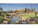 Stunning view of the community center with green spaces, a bridge, and beautiful landscaping at 9856 E Palladium Dr, Mesa, AZ 85212
