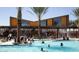 Exterior view of a community swimming pool with palm trees, lounge chairs, and ample space for Gathering fun at 9856 E Palladium Dr, Mesa, AZ 85212