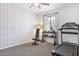 Dedicated exercise room featuring a treadmill, weights, and stylish chevron wallpaper at 9856 E Palladium Dr, Mesa, AZ 85212