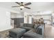 Open-concept living area with a gray sectional sofa and view to a modern kitchen at 9856 E Palladium Dr, Mesa, AZ 85212