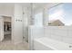 Bright shower and bathtub with tiled walls, glass partition and walk-in closet access at 9856 E Palladium Dr, Mesa, AZ 85212