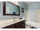 A well-lit bathroom with a large mirror, white countertops, and stylish blue accents at 1022 N Kirby St, Gilbert, AZ 85234